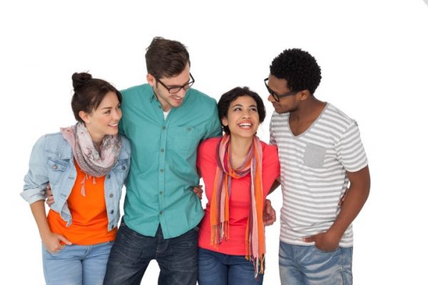 Portrait of four happy young friends standing over white background